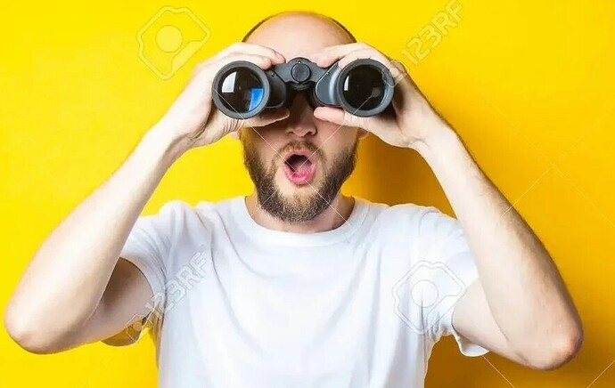 153356618-surprised-shocked-bearded-young-man-looks-through-binoculars-on-a-yellow-background-~3