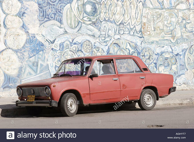red-lada-parked-by-a-mural-in-havana-cuba-AGHYT7
