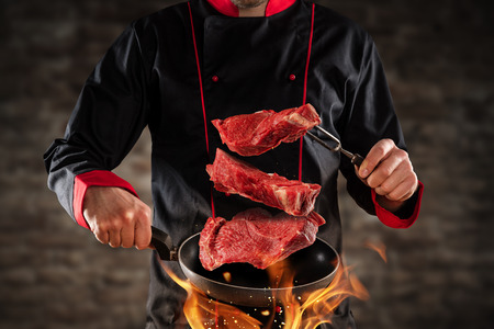 119692598-closeup-of-chef-throwing-raw-beef-steaks-into-the-air-concept-of-food-preparation-grill-and-barbecue