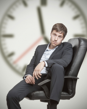14433306-frustré-jeune-homme-d-affaires-en-attente-pour-la-fin-de-la-journée-de-travail